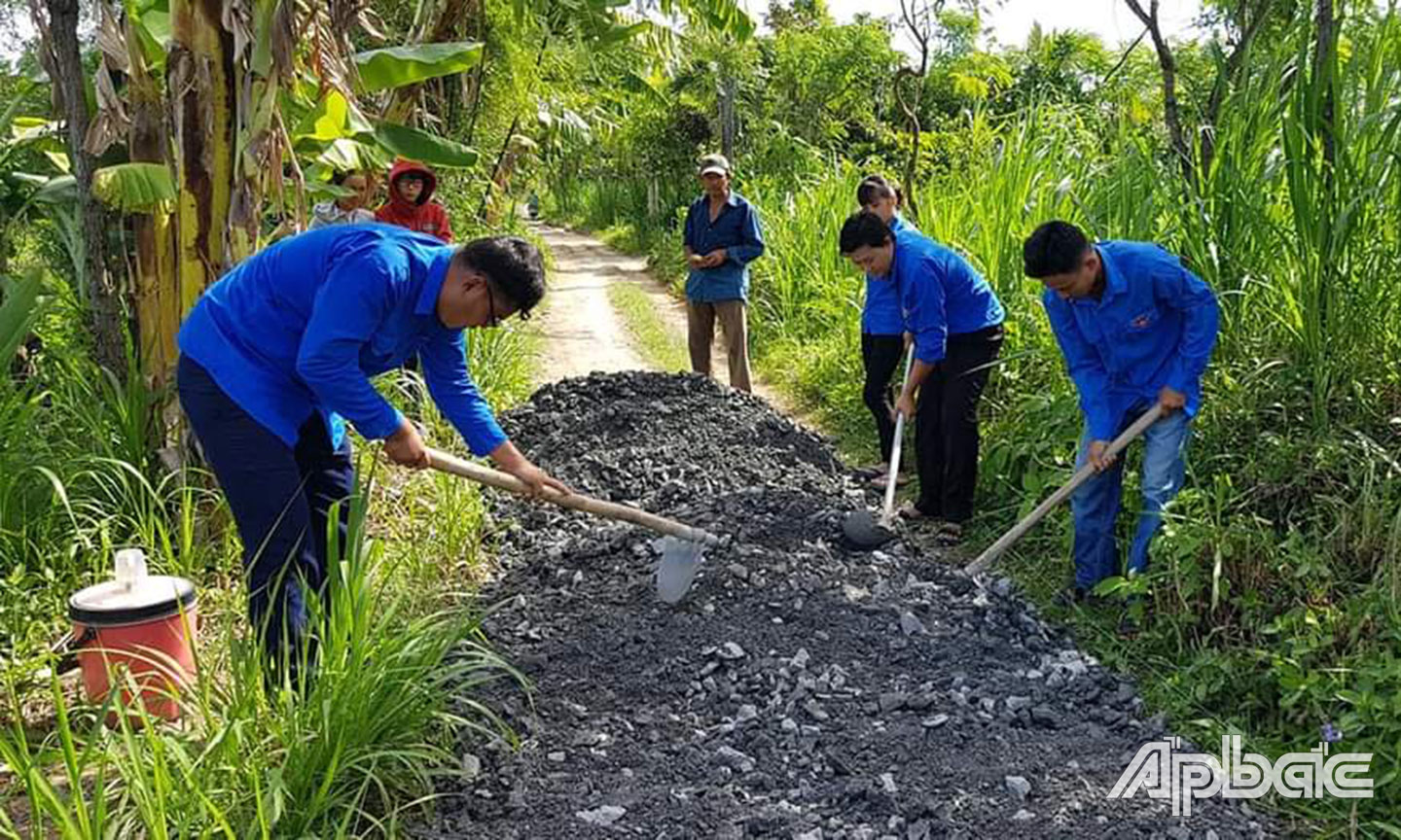 ĐVTN xã Bình Ân trồng cây xanh, trồng hoa, dặm vá đường trên các tuyến đường liên ấp. Ảnh: ĐỖ HIẾU