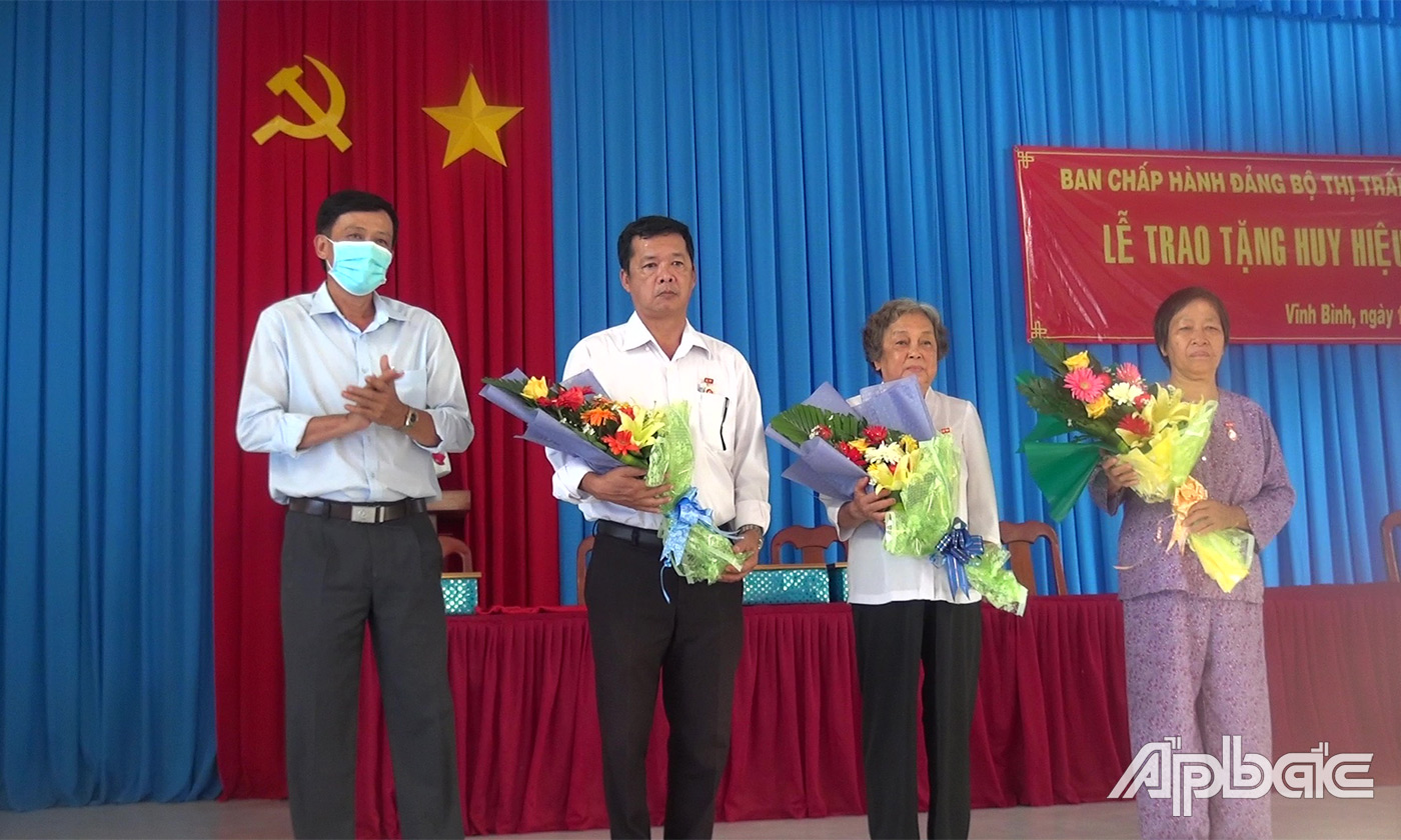 Đồng chí Đinh Tấn Hoàng trao Huy hiệu và chúc mừng các đồng chí