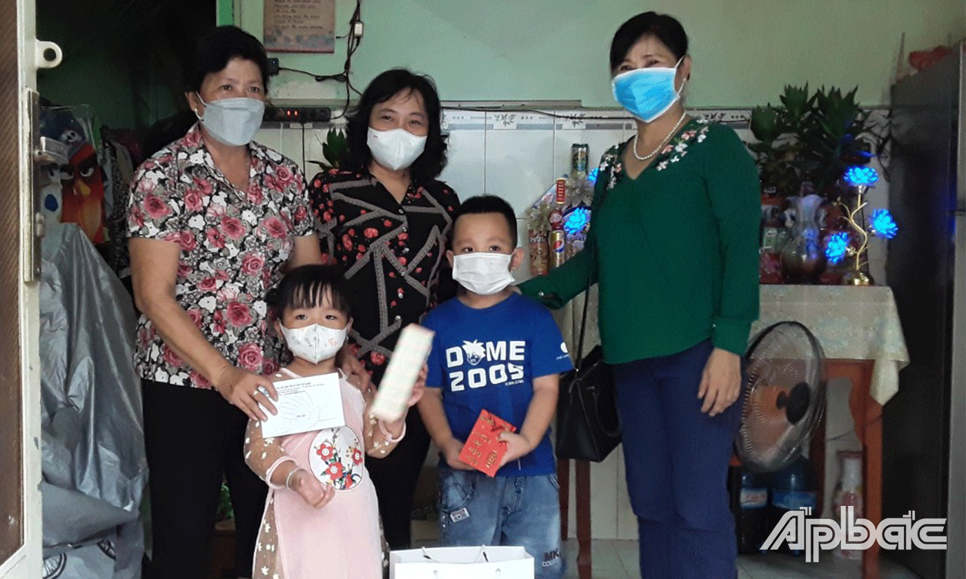 Phó Chủ tịch Hội LHPN tỉnh Đặng Thị Ngọc Điệp (giữa) trao hỗ trợ kinh phí cho 2 trẻ mồ côi ở Phường 2, TP. Mỹ Tho.