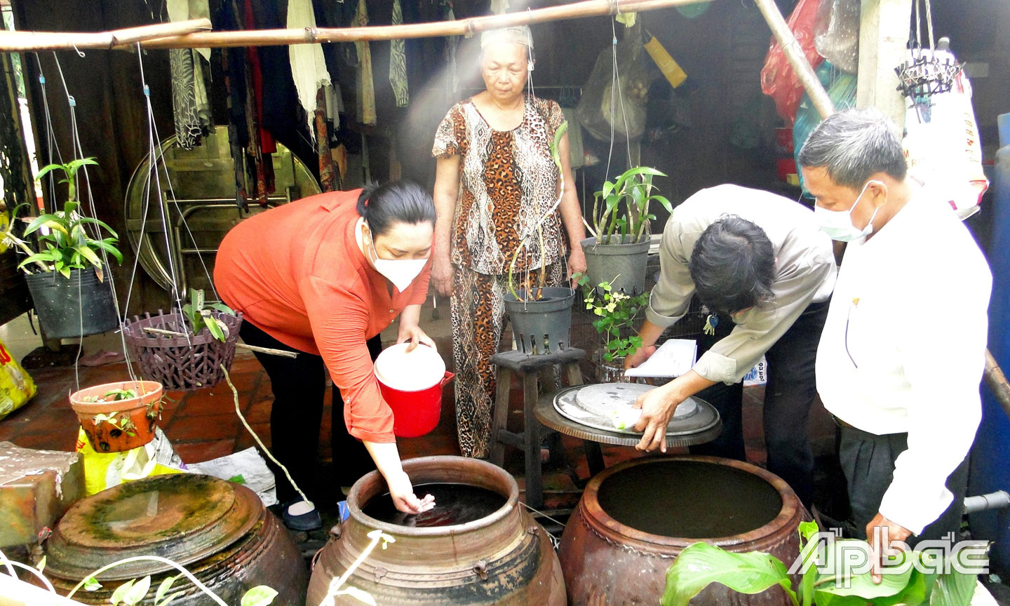 Kiểm tra lăng quăng hộ gia đình Bà Nguyễn Thị Bảy, Ấp 3B( Hộ có rất nhiều vật chứa nước lớn và xung quanh nhà có nhiều vật dụng linh tinh có lăng quăng).