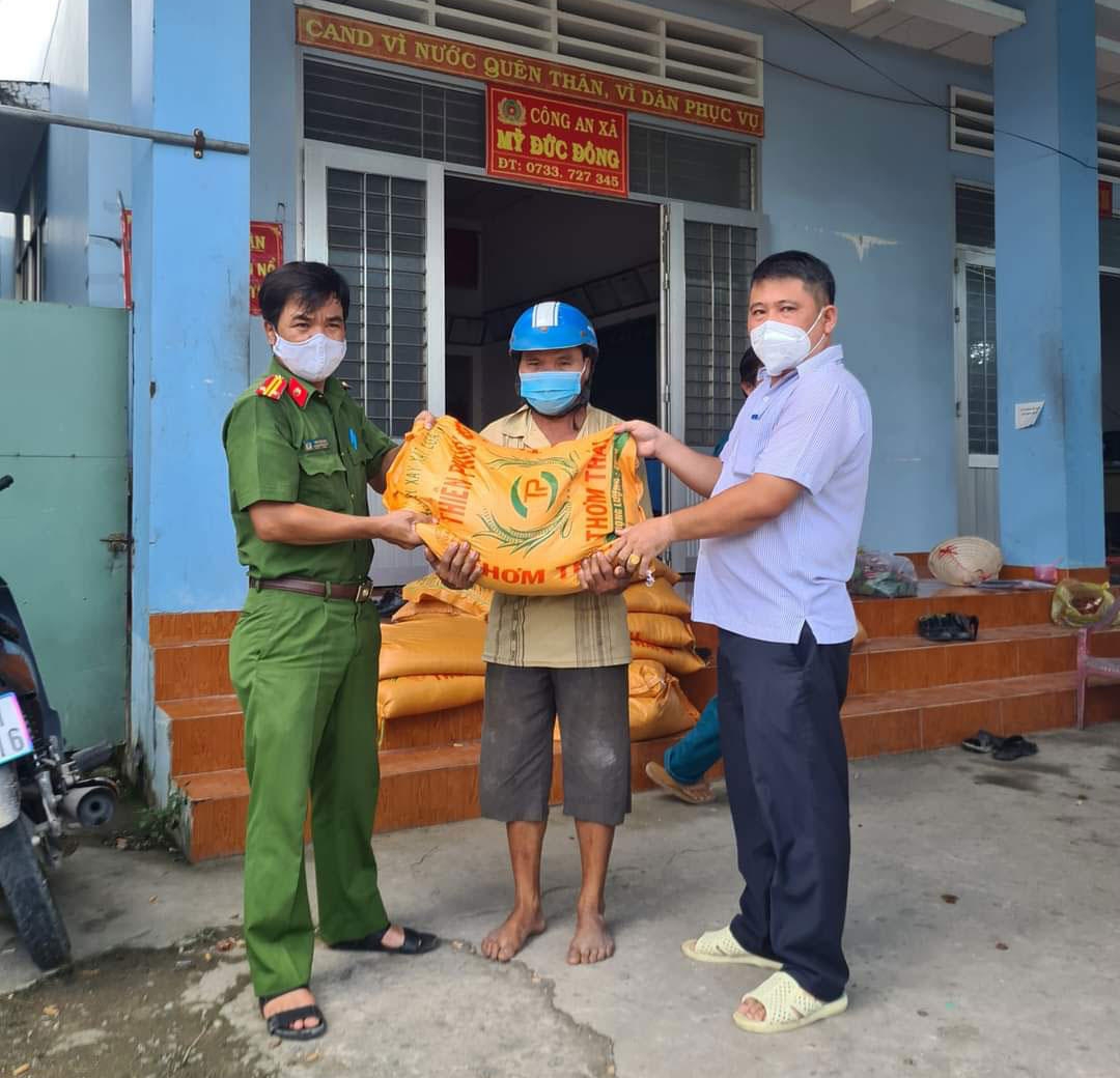 Đồng chí Phùng Thanh Việt (phải) trao nhu yếu phẩm cho người dân.