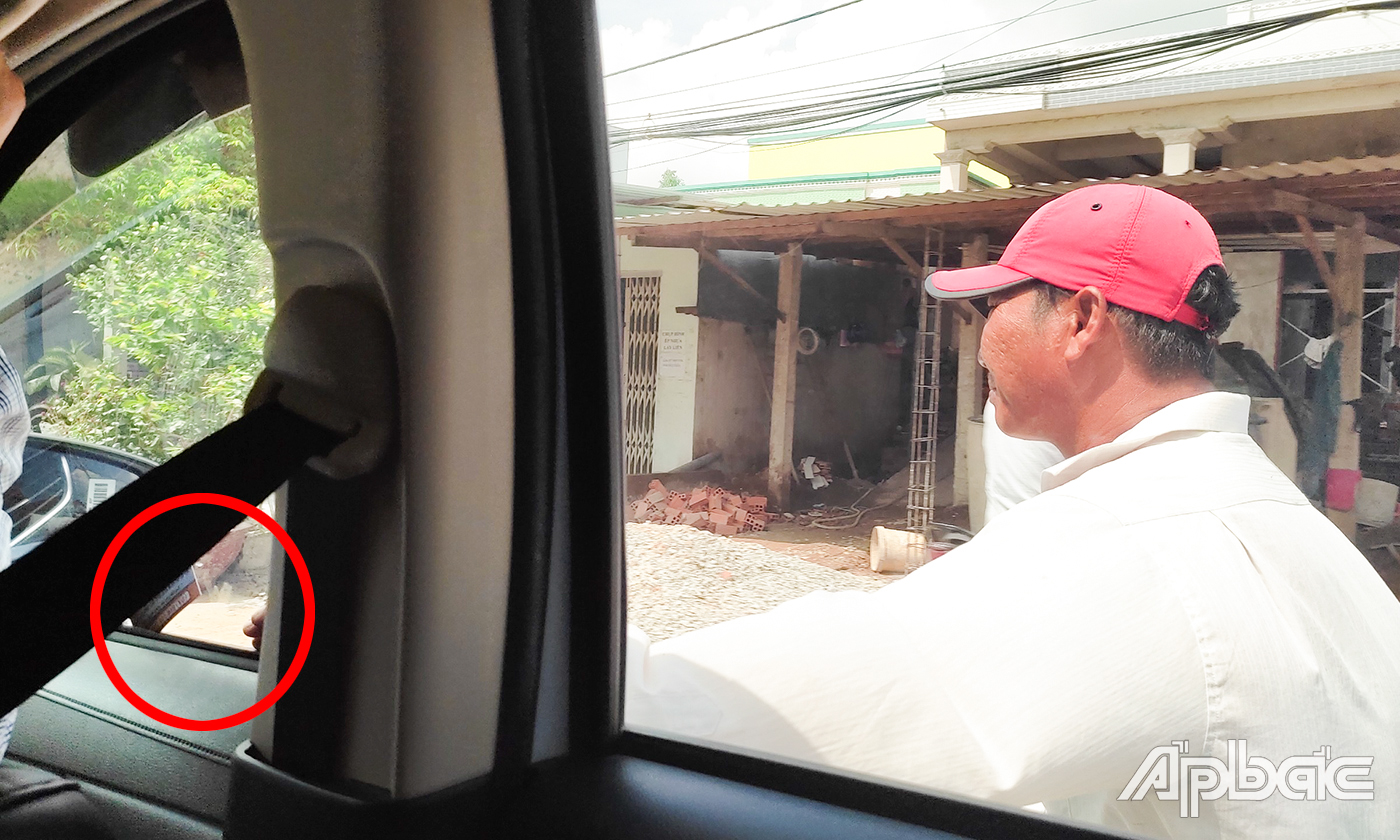 Người đàn ông chèo kéo, kẹp danh thiếp của quán ăn lên cửa kính xe ô tô. 
