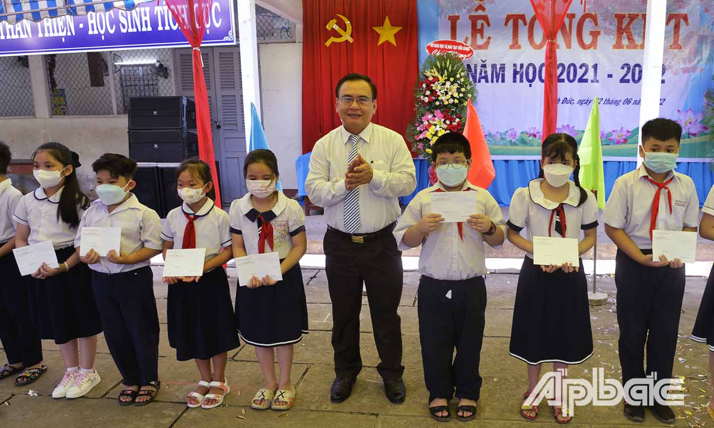 Đồng chí Võ Văn Bình trao học bổng cho các em học sinh vượt khó học tốt.