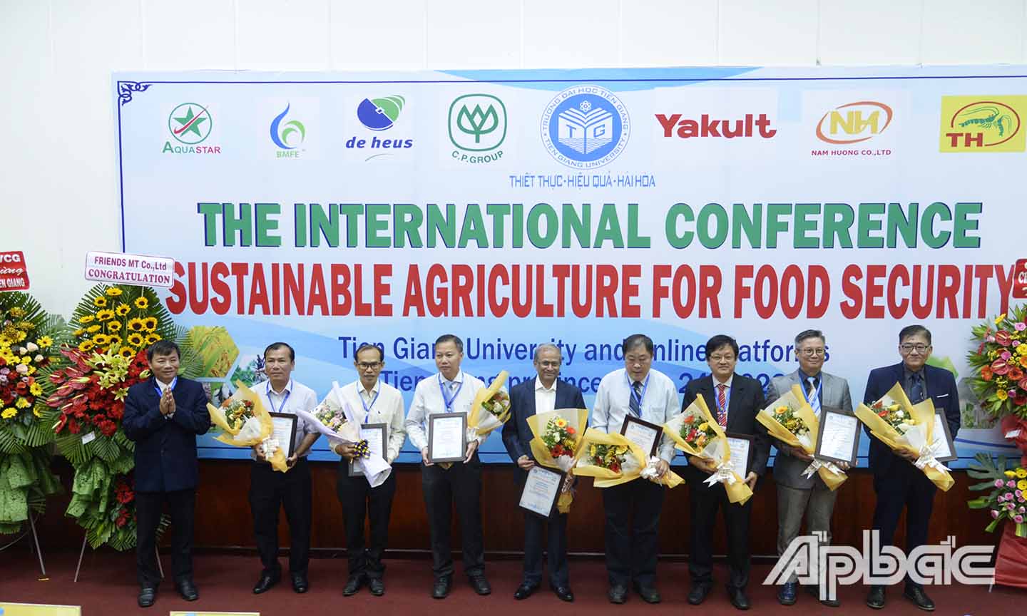 Đại diện Hội đồng Trường Đại học Tiền Giang tặng hoa cho các đại biểu, nhà khoa học tham dự hội thảo.