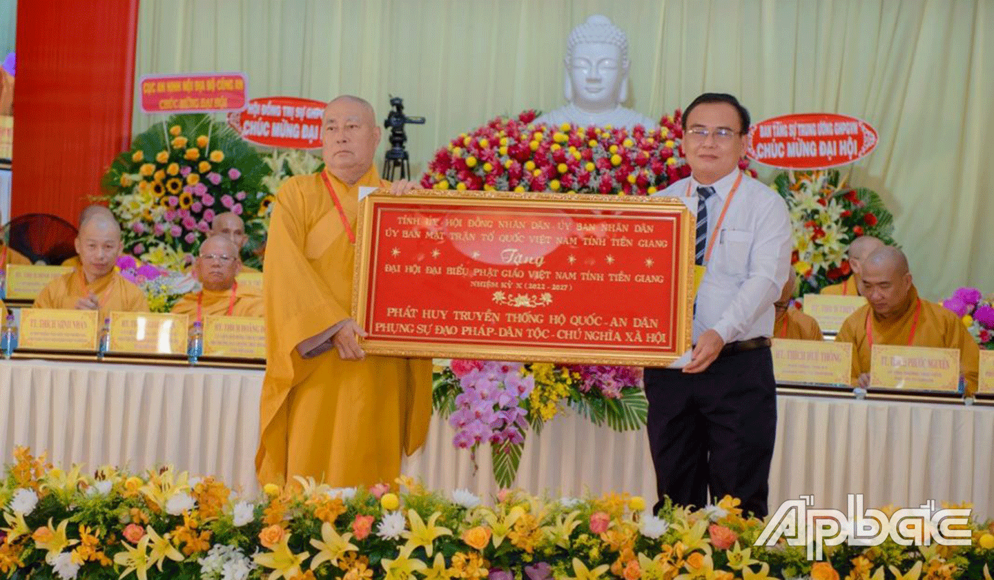 Đồng chí Võ Văn Bình trao bức khánh của Tỉnh ủy, HĐND, UBND, Ủy ban MTTQ tỉnh tặng đại hội với dòng chữ “Phát huy truyền thống hộ quốc an dân, Phụng sự đạo pháp – Dân tộc – Chủ nghĩa xã hội”