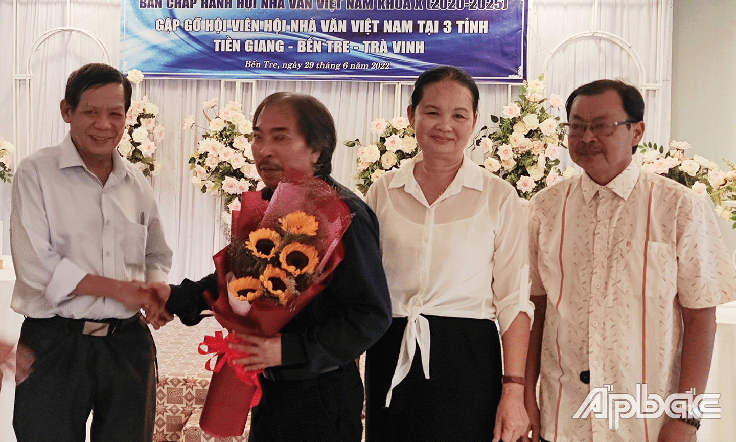 Nhà thơ Kim Ba (bìa trái) - Chủ tịch Hội Văn học Nghệ thuật Nguyễn Đình Chiểu tặng hoa cho nhà thơ Nguyễn Quang Thiều - Chủ tịch Hội Nhà văn Việt Nam