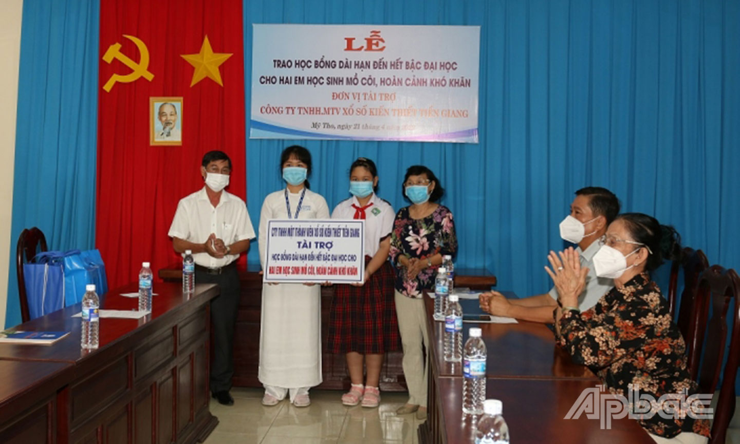 Ông Trần Văn An, Giám đốc Công ty TNHH MTV Xổ số kiến thiết Tiền Giang trao học bổng cho học sinh có hoàn cảnh khó khăn. 	Ảnh: X.U