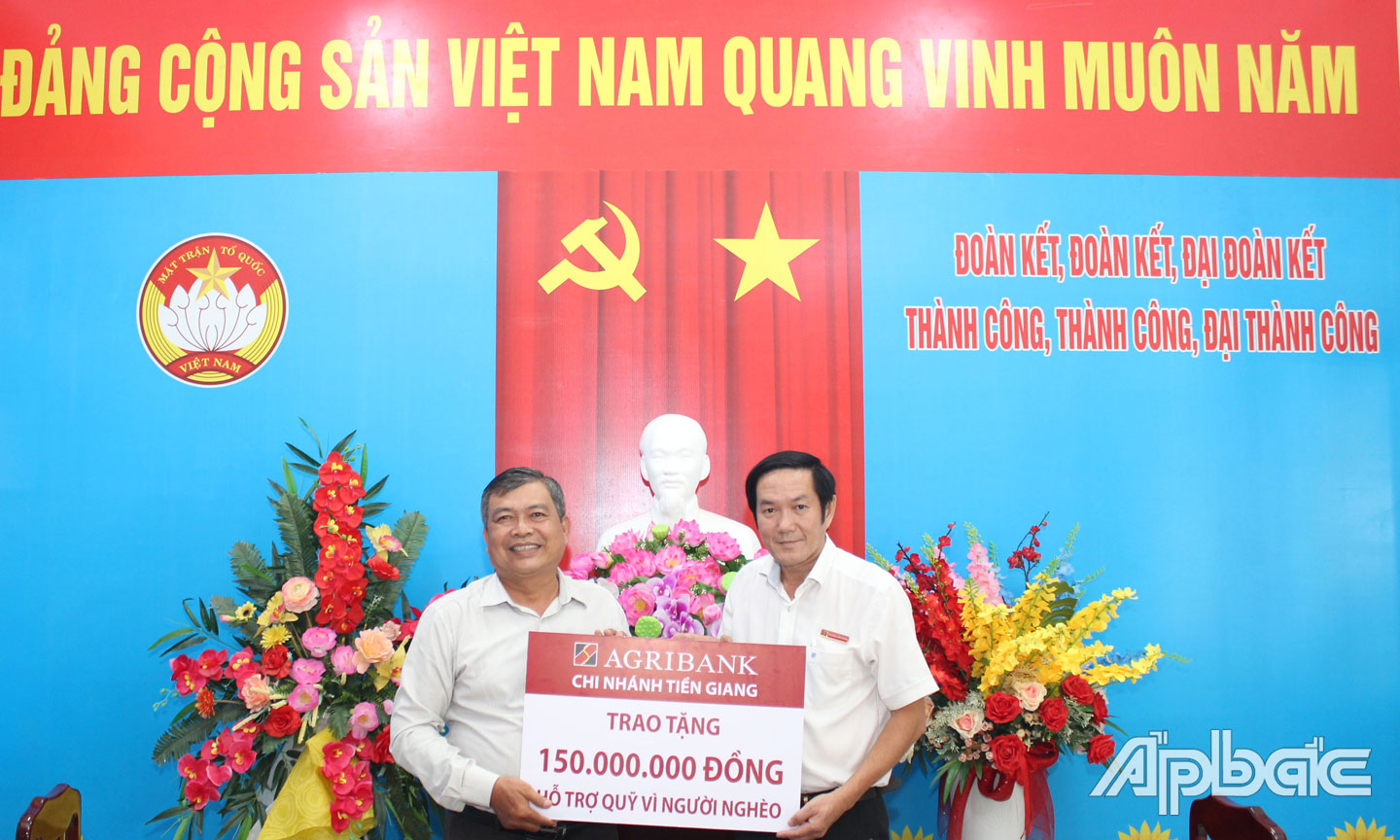 Ông Trương Văn Đoàn, Phó Giám đốc Agribank Tiền Giang (bên phải) trao biển tượng trưng số tiền ủng hộ cho ông Bùi Văn Bảo, Chủ tịch MTTQ TP. Mỹ Tho.
