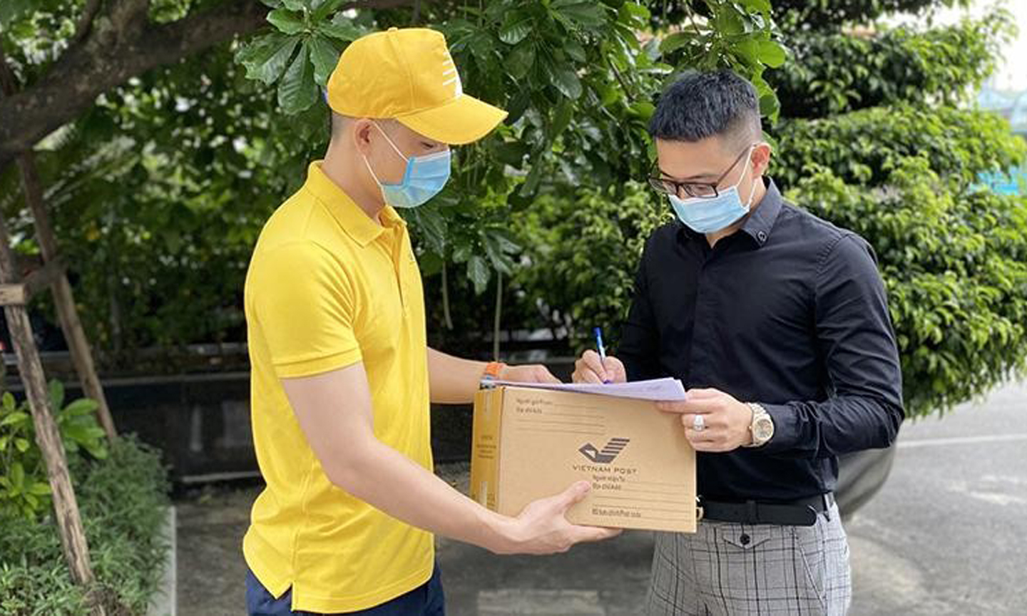 Nhân viên Bưu điện Việt Nam chuyển phát đến tận tay khách hàng và thu tiền trực tiếp (Ảnh: VietnamPost).