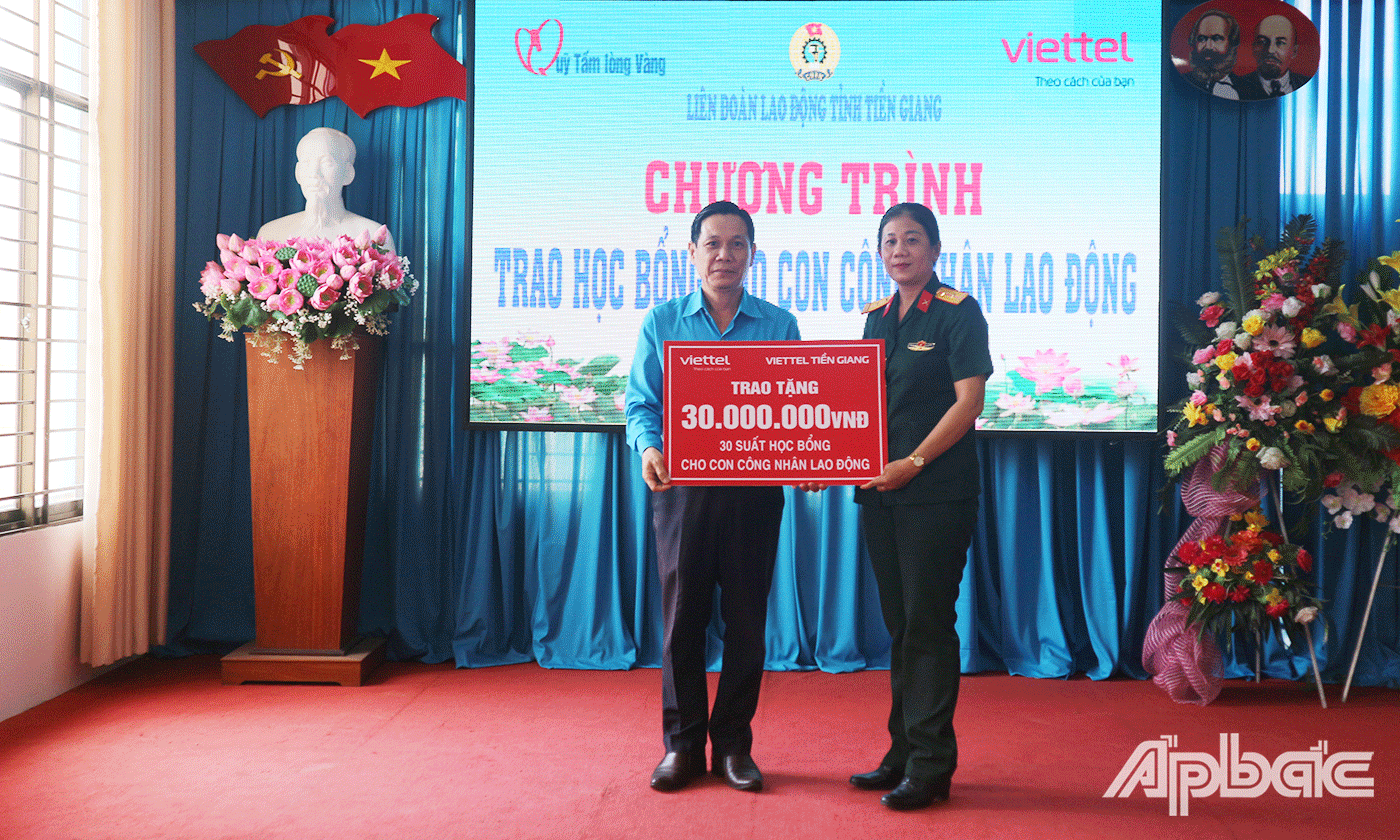 Bà Huỳnh Thị Kiều Trang, Phó Giám đốc Viettel Tiền Giang trao tặng bảng tương trưng 30 suất học bổng cho con công nhân lao động cho Liên đoàn Lao động tỉnh Tiền Giang