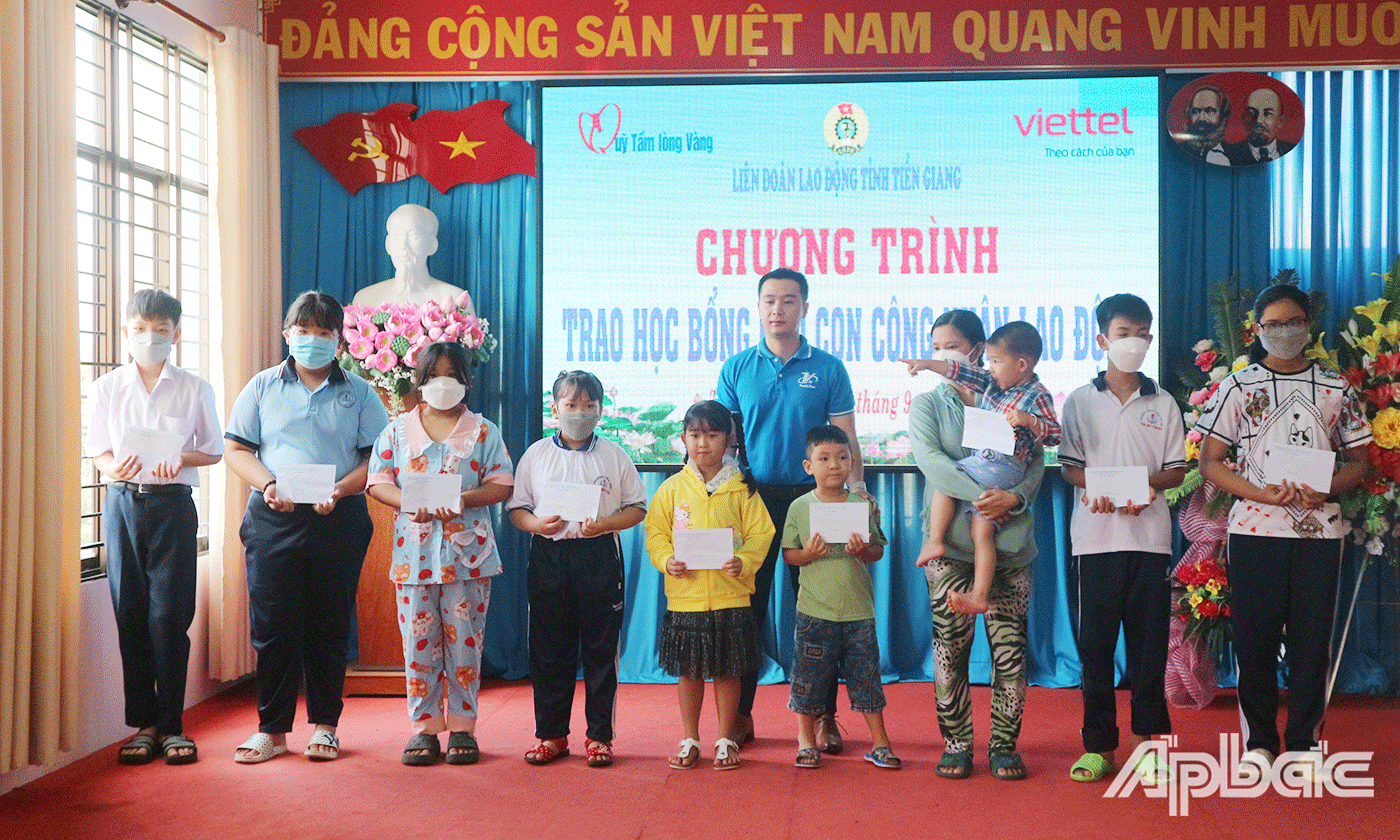 Đại diện Công ty TNHH Thương mại Du lịch và Sự kiện Tín Việt trao học bổng cho các em học sinh