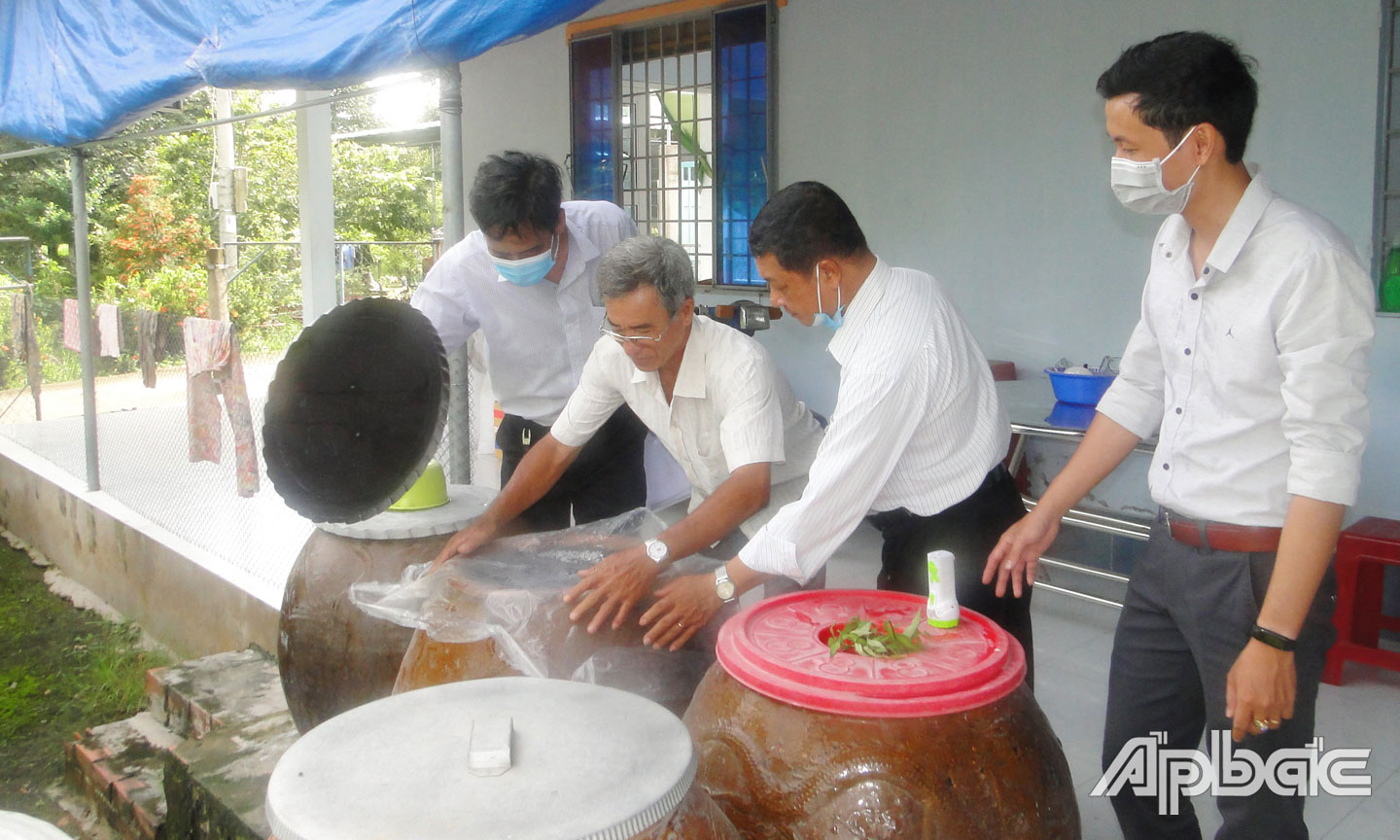 Cán bộ y tế hướng dẫn hộ gia đình đậy lu diệt lăng quăng, đồng thời không cho muỗi vào đẻ trứng và kiểm tra lăng quăng hàng tuần.