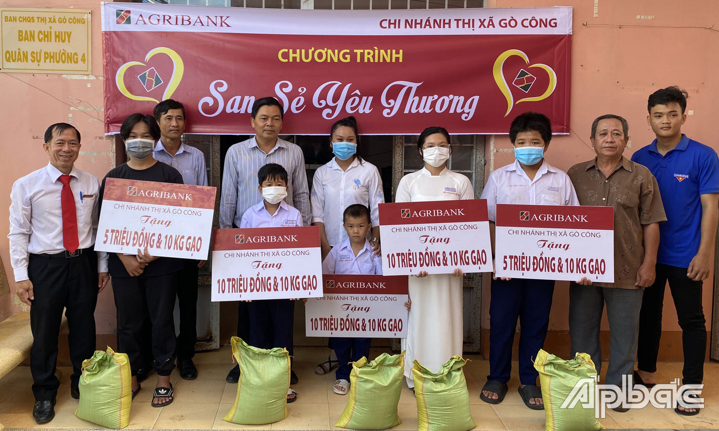 Ông Hoàng Duy Hùng, Chủ tịch CĐCS thành viên, Phó Giám đốc Agribank TX. Gò Công (bìa trái) và Ông Lê Văn Tiến, Phó Chủ tịch UBMTTQ TX. (thứ hai từ phải) cùng lãnh đạo chính quyền Phường 4 trao bảng tượng trưng số tiền và gạo cho những hoàn cảnh được hỗ trợ
