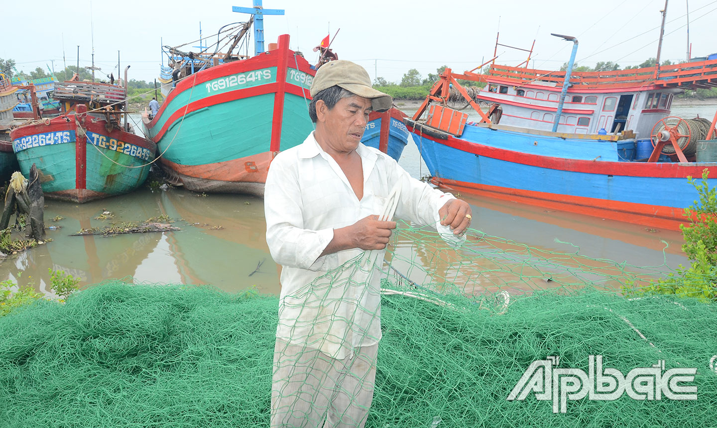 Ông Tồn vá lưới để chuẩn bị ra khơi.