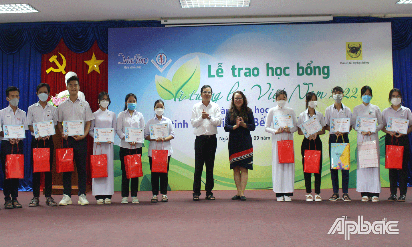 Phó Giám đốc Sở GD-ĐT Nguyễn Phương Toàn và Phó Tổng Biên tập Báo Mực tím Trần Gia Bảo trao học bổng.  