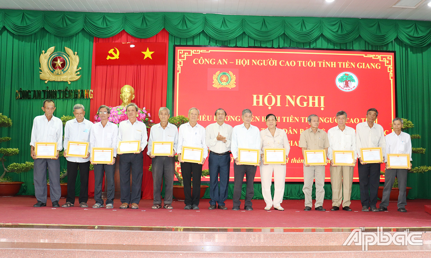 Đồng chí Nguyễn Ngọc Minh, Chủ tịch Hội Người Cao tuổi tỉnh Tiền Giang trao trao tặng Giấy khen của Giám đốc Công an tỉnh cho các cá nhân có nhiều thành tích xuất sắc trong Phong trào TDBVANTQ giai đoạn 2016 – 2021.  