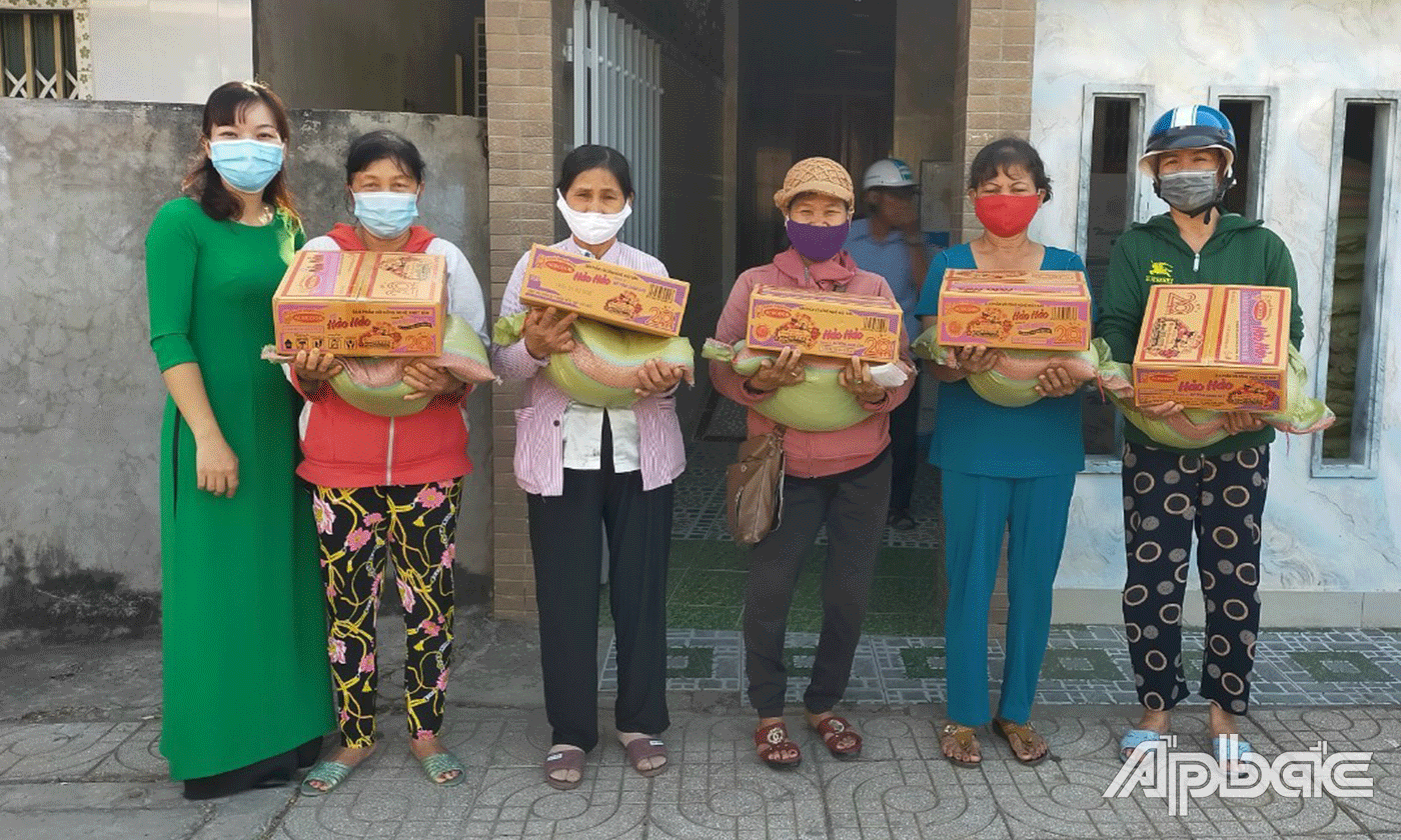 Chị Thanh Thảo (áo dài) trao quà cho phụ nữ khó khăn.