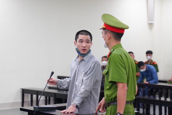Tại tòa, bị cáo Huyên nặng tai, không nghe được tiếng hội đồng xét xử hỏi, lực lượng hỗ trợ tư pháp truyền lại thông tin cho bị cáo. Ảnh: ĐỖ TRUNG