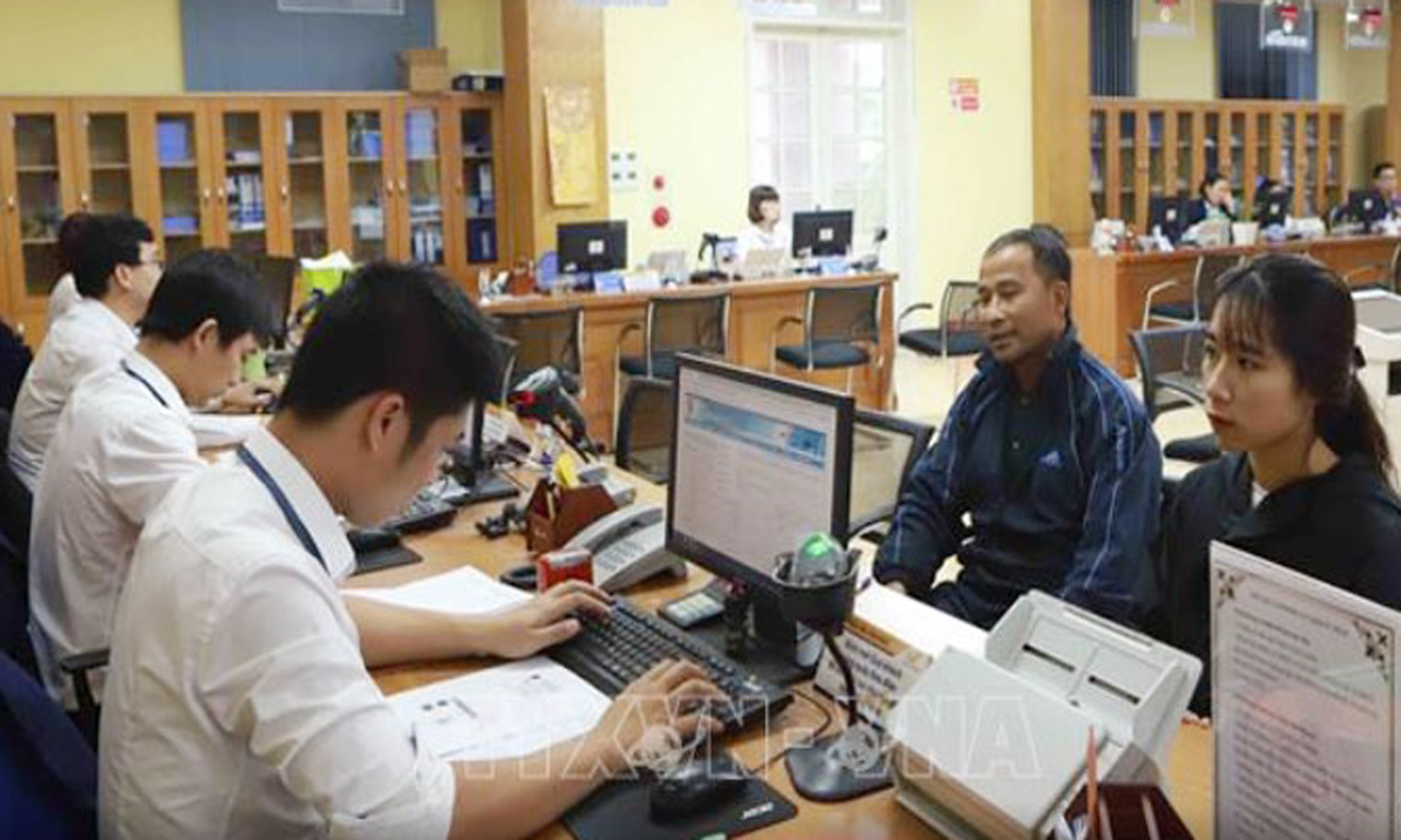 Người dân nhận kết quả giải quyết thủ tục hành chính.Ảnh:TTXVN.