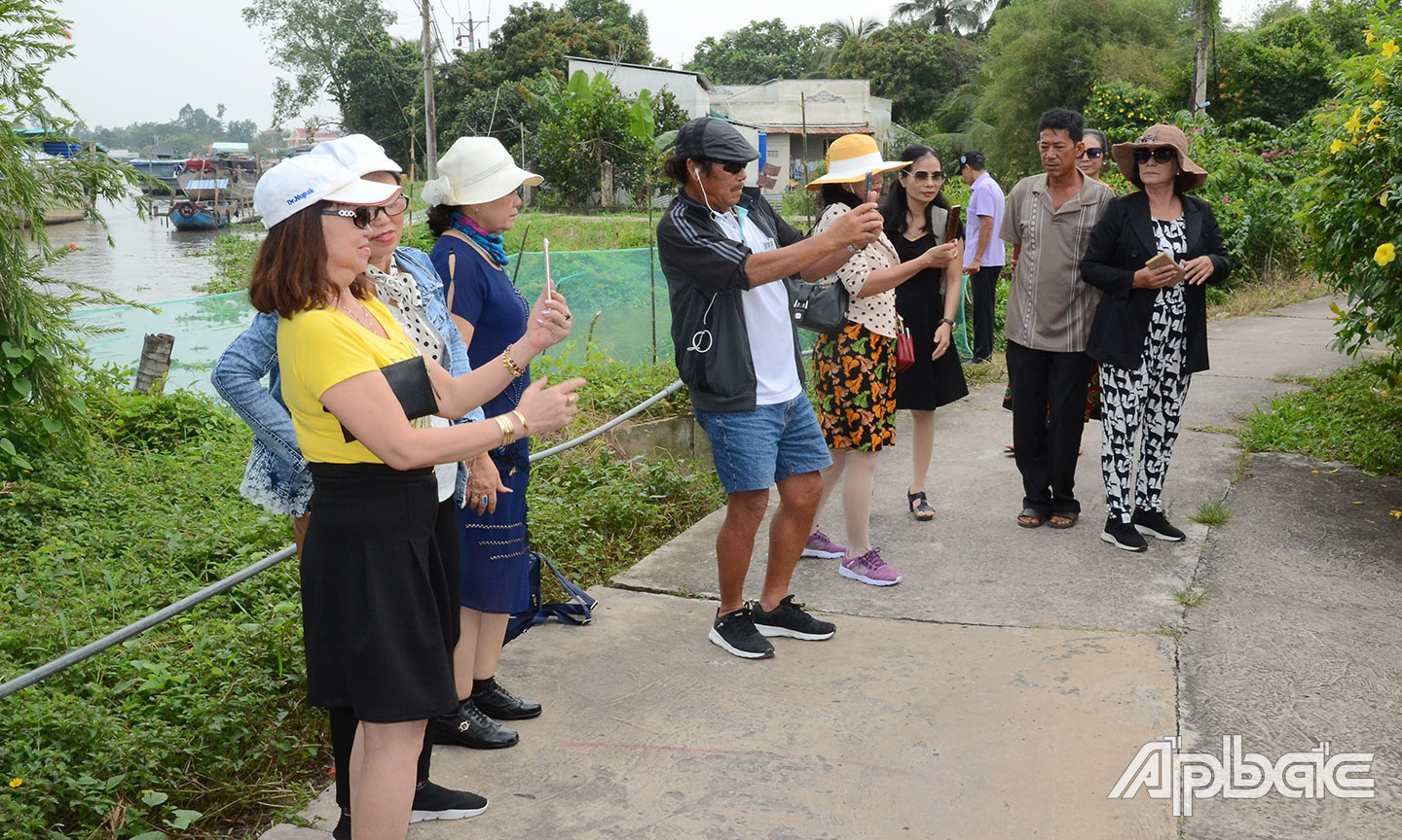 Du khách tham quan và hoạt động biểu diễn đờn ca tài tử tại Lễ hội Văn hóa - Du lịch Làng cổ Đông Hòa Hiệp lần thứ IV.