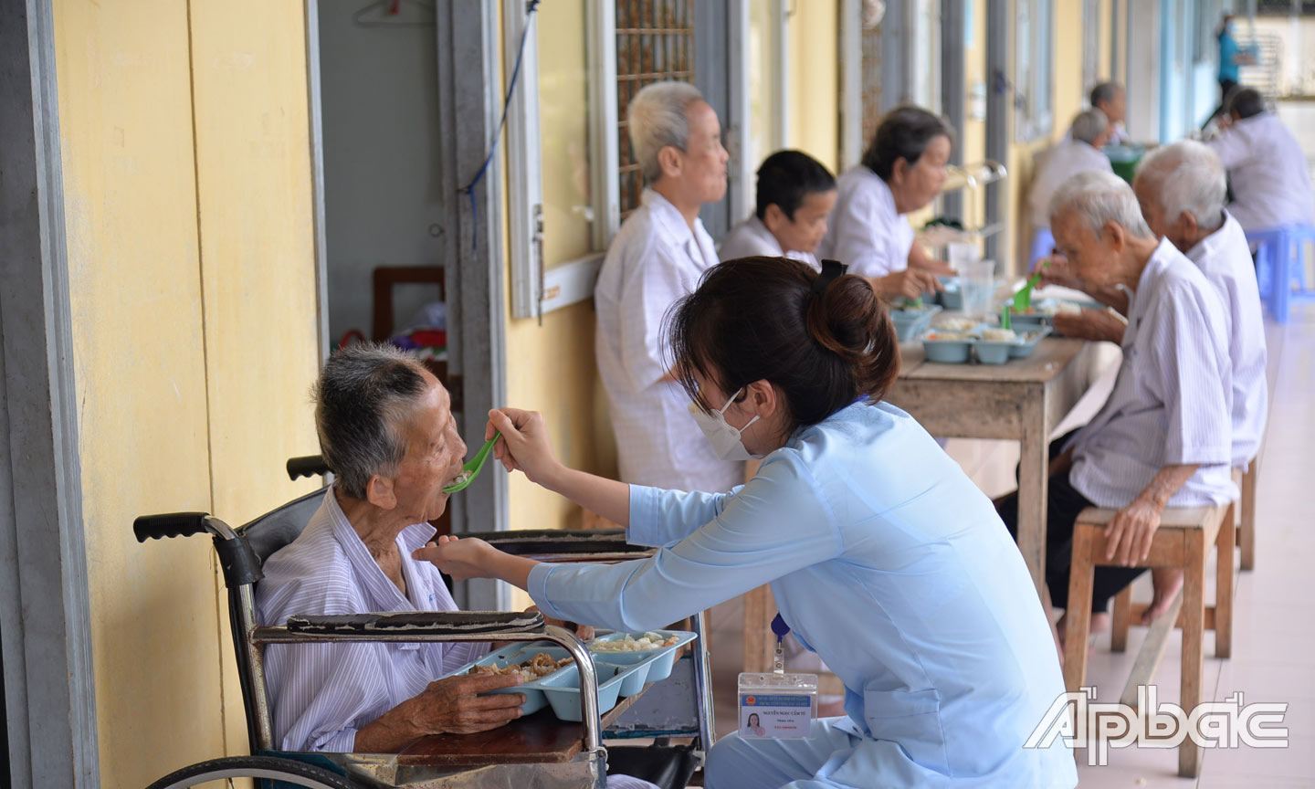 Nhân viên đút cơm cho các cụ sức khỏe yếu.