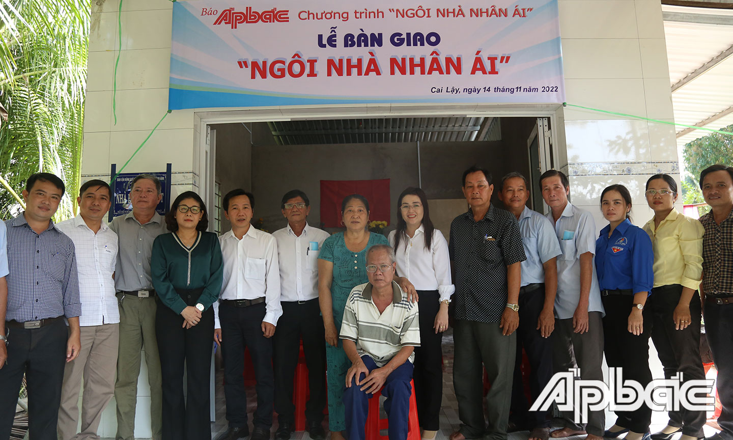 Gia đình ông Phương chụp ảnh lưu niệm cùng các đại biểu bên căn nhà mới.