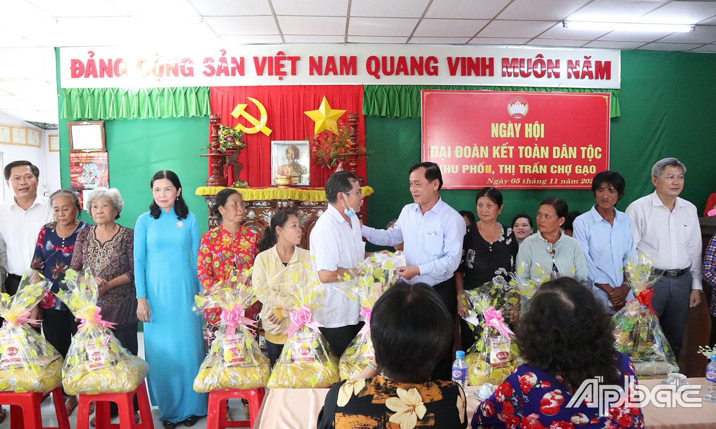 Phó Bí thư Tỉnh ủy, Chủ tịch UBND tỉnh Tiền Giang Nguyễn Văn Vĩnh tặng quà cho các gia đình có người thân tử vong do Covid-19 tại Ngày hội Đại đoàn kết toàn dân tộc ở khu II, thị trấn Chợ Gạo, huyện Chợ Gạo năm 2022.                                                                                                                                       Ảnh: NGỌC DUYÊN