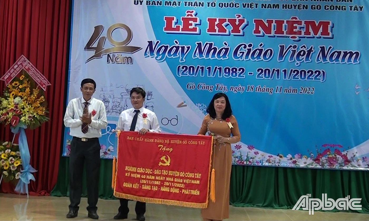 Đồng chí Đinh Tấn Hoàng trao bức trướng của Đảng bộ huyện cho lãnh đạo Phòng GD-ĐT huyện