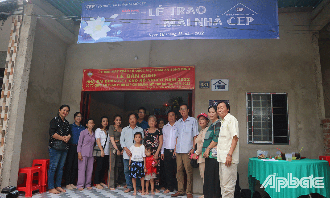 Gia đình anh Phong cùng đại biểu chụp ảnh bên ngôi nhà mới