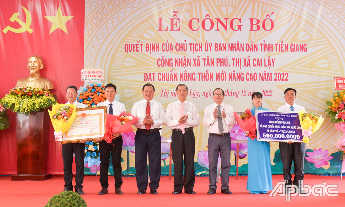 Năm 2022, tỉnh Tiền Giang đạt nhiều kết quả khả quan trong xây dựng NTM. (Ảnh: Lãnh đạo ngành Nông nghiệp tỉnh  Tiền Giang và TX. Cai Lậy trao Bằng công nhận đạt chuẩn NTM nâng cao, Bảng tượng trưng tặng công trình phúc lợi cho  xã Tân Phú).                                                                                                              			                                                  Ảnh: HÀ NAM