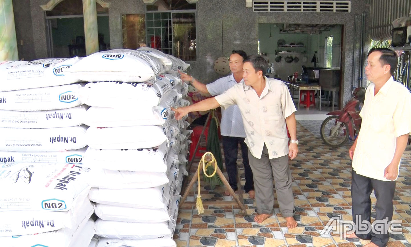 Ông Ngô Văn Em (giữa) chia sẻ cách sử dụng từng loại thức ăn cho cá theo tuổi.