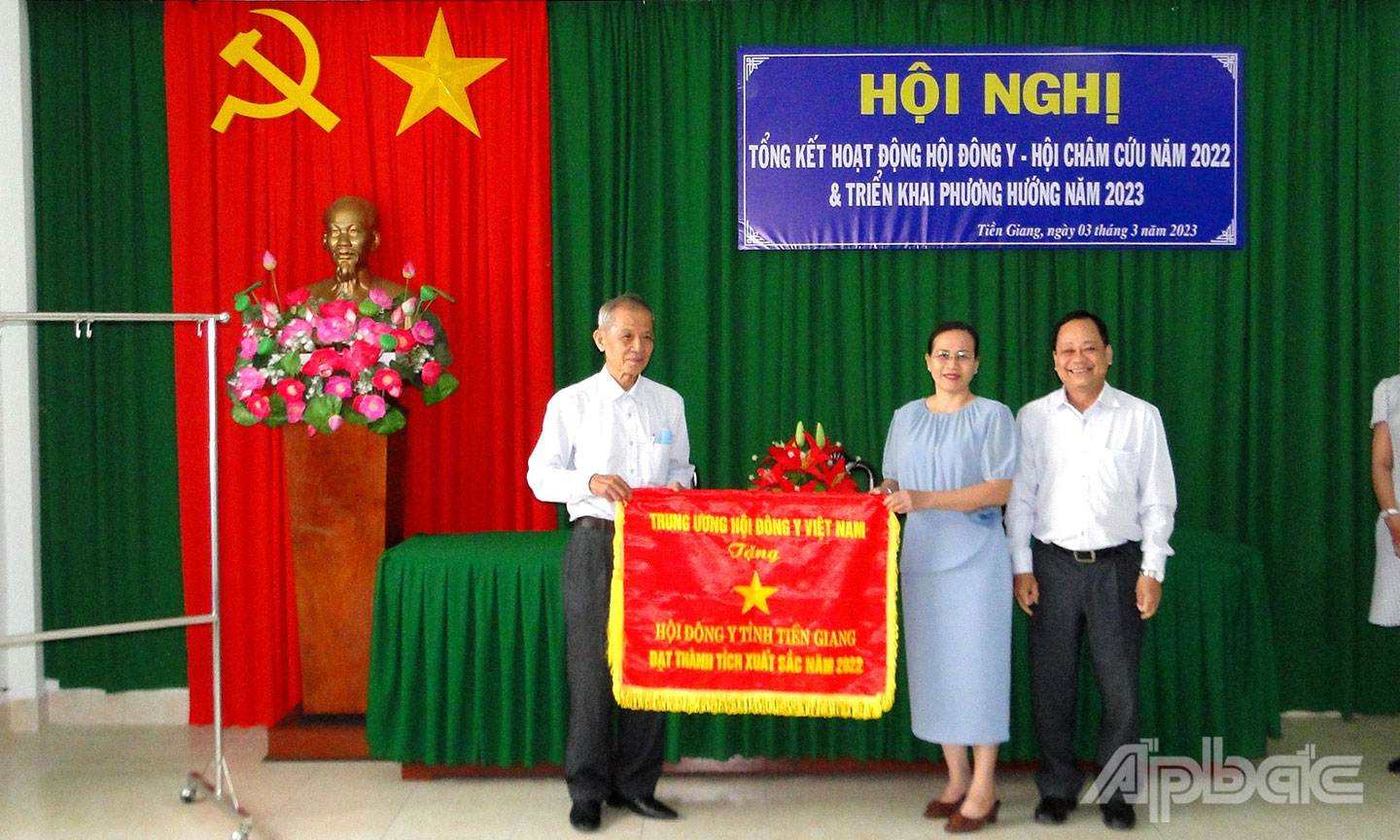 Bác sĩ CK2 Nguyễn Thanh Linh(bìa phải), Phó Giám đốc Sở Y tế trao Cờ của Hội Đông y Việt Nam cho Hội Đông y tỉnh Tiền Giang.