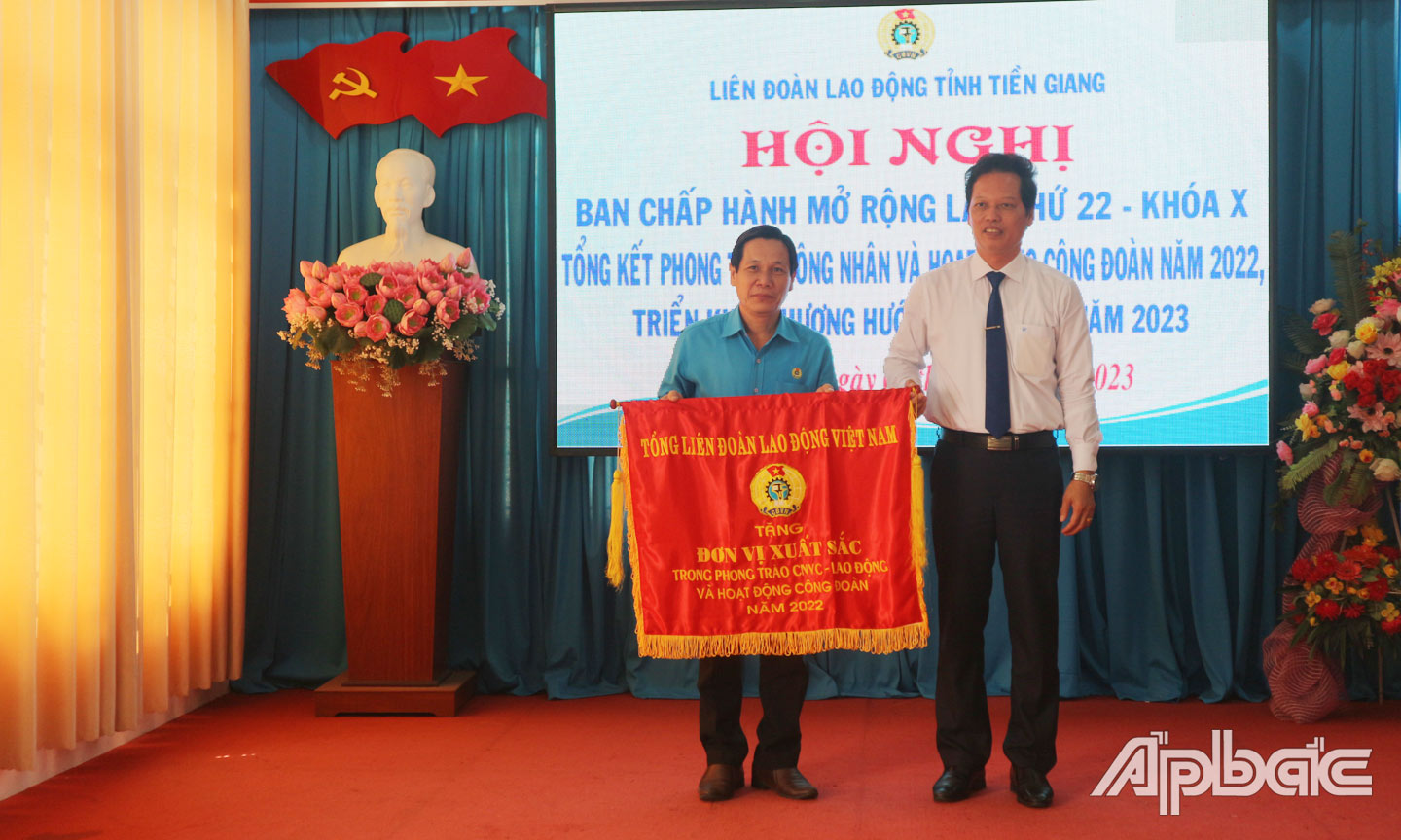 Phó Chủ tịch UBND tỉnh Nguyễn Thành Diệu trao Cờ thi đua của Tổng LĐLĐ Việt Nam cho LĐLĐ tỉnh.