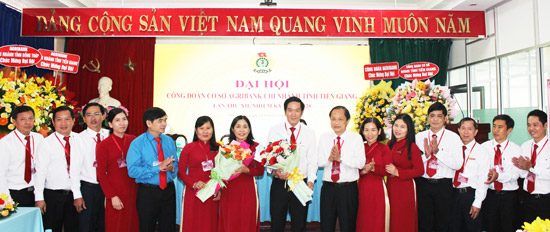  BCH CĐCS nhiệm kỳ mới ra mắt và nhận hoa chúc mừng của ông Ngô Anh Tuấn, Phó Chủ tịch Công đoàn Agribank (áo xanh) và ông Nguyễn Văn Huỳnh, Bí thư Đảng ủy, Giám đốc Agribank Tiền Giang (thứ 7 từ phải)
