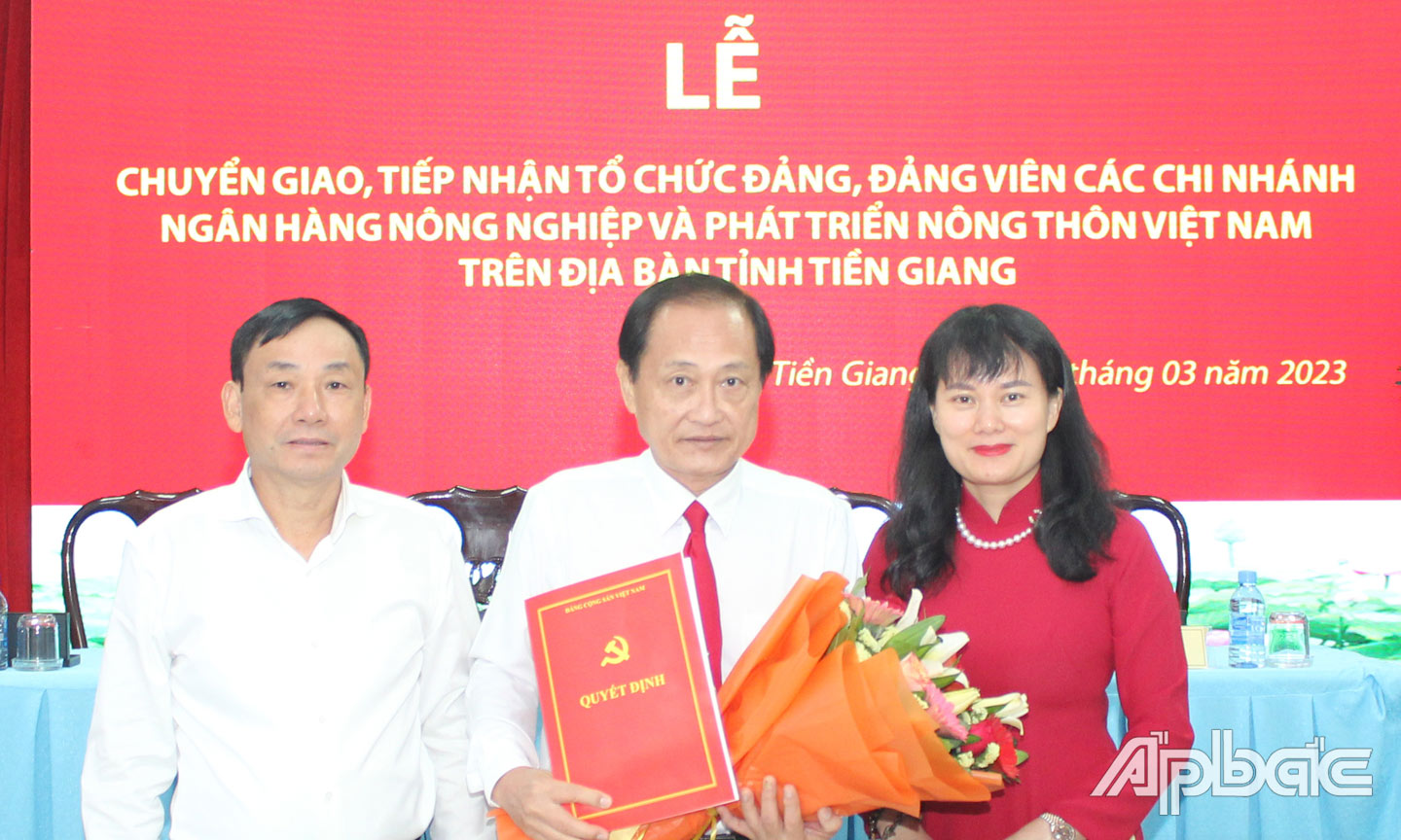 Đ/c Phùng Thị Bình, Ủy viên BCH Đảng bộ Agribank trao Quyết định tiếp nhận tổ chức Đảng và các đảng viên cho đ/c Nguyễn Văn Huỳnh, Bí thư Đảng ủy, Giám đốc Agribank Tiền Giang (đứng giữa).