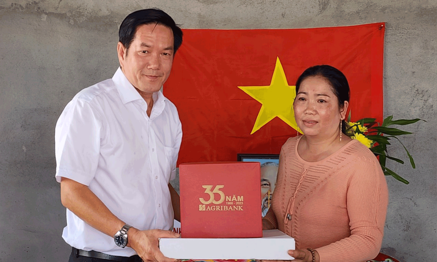 Ông Trương Văn Đoàn, Phó Giám đốc Agribank Tiền Giang tặng quà cho gia đình bà Lê Kim Hương tại Lễ bàn giao nhà.