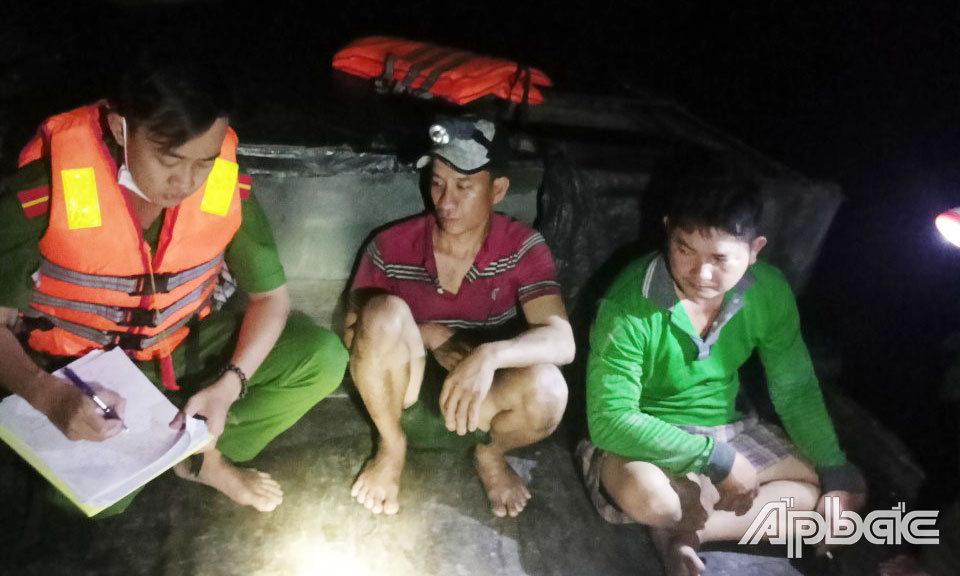 Lực lượng Công an lập biên bản ghe gỗ khai thác cát trái phép.