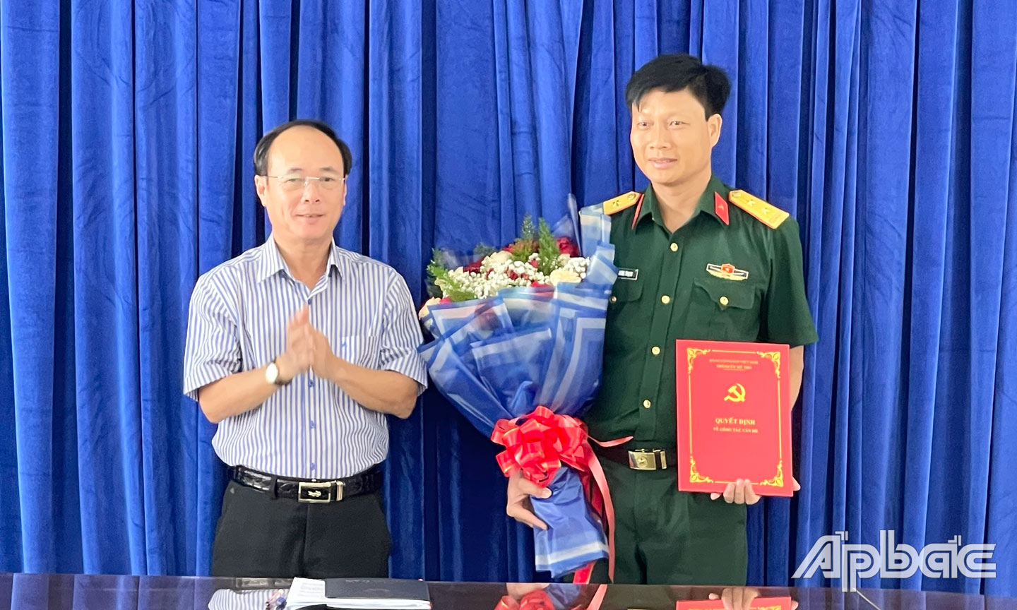 Đồng chí Trần Kim Trát, Ủy viên Ban Thường vụ Tỉnh ủy, Bí thư Thành ủy Mỹ Tho trao quyết định, tặng hoa chúc mừng đồng chí Phạm Quang Thạch.
