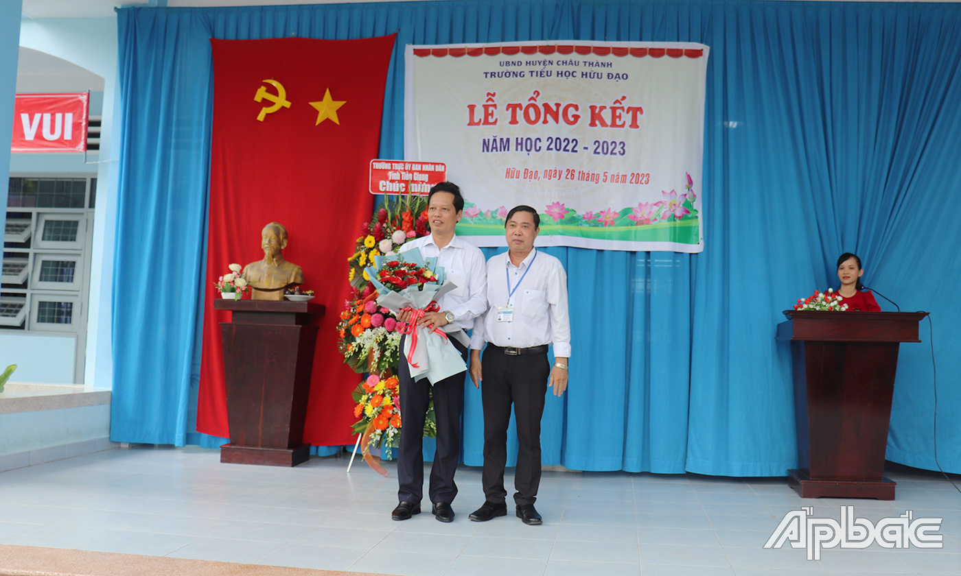 Đại diện Trường Tiểu học Hữu Đạo trao hoa cảm ơn đồng chí Nguyễn Thành Diệu.