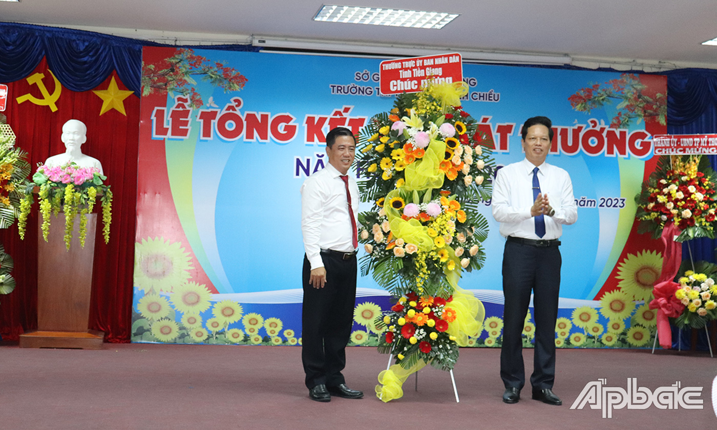 Đồng chí Nguyễn Thành Diệu tặng hoa chúc mừng hội đồng sư phạm nhà trường.