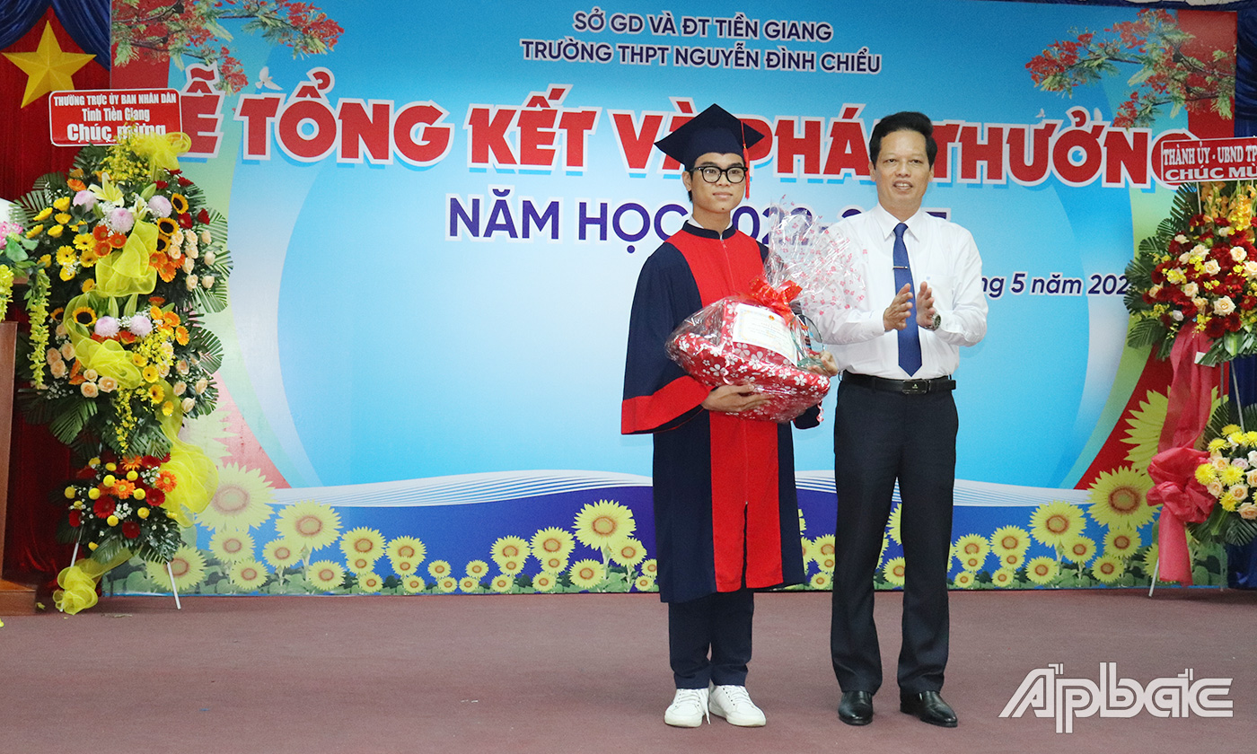 Đồng chí Nguyễn Thành Diệu tặng cho học sinh Nguyễn Đoàn Đăng Khoa, học sinh lớp 11T3 đạt danh hiệu học sinh xuất sắc toàn diện tiêu biểu nhất trường.