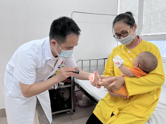 Thăm khám cho trẻ mắc tay chân miệng.