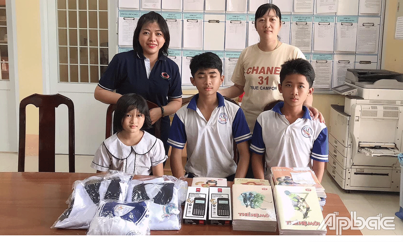 Chị Nương (phía sau bên phải) trao quà cho các em.