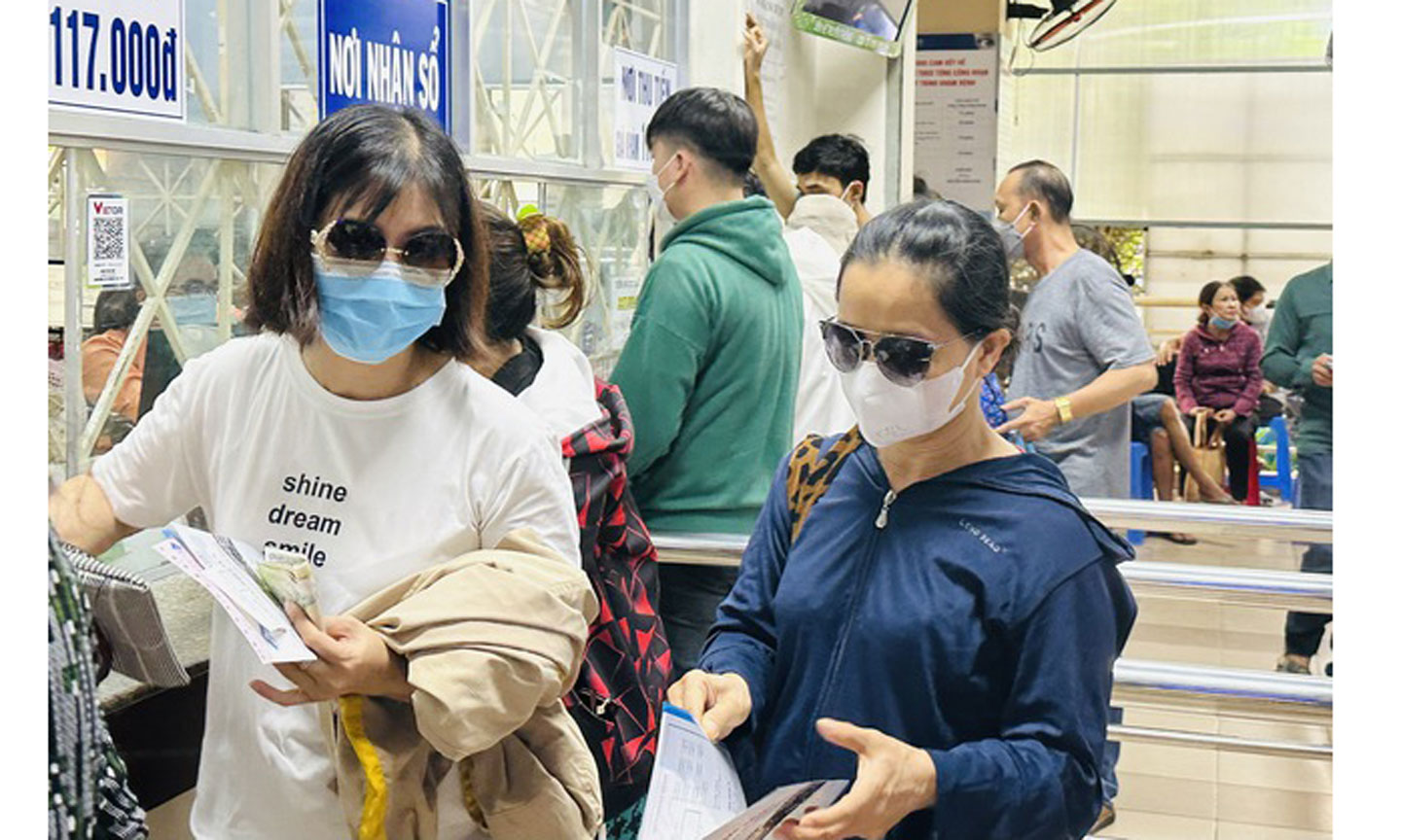 Chị Nga (áo trắng) và bà Thúy (áo xanh tím than) cùng xếp hàng đi khám đau mắt đỏ tại Bệnh viện Mắt TPHCM sáng 6/9/2023. Ảnh: Kim Vân