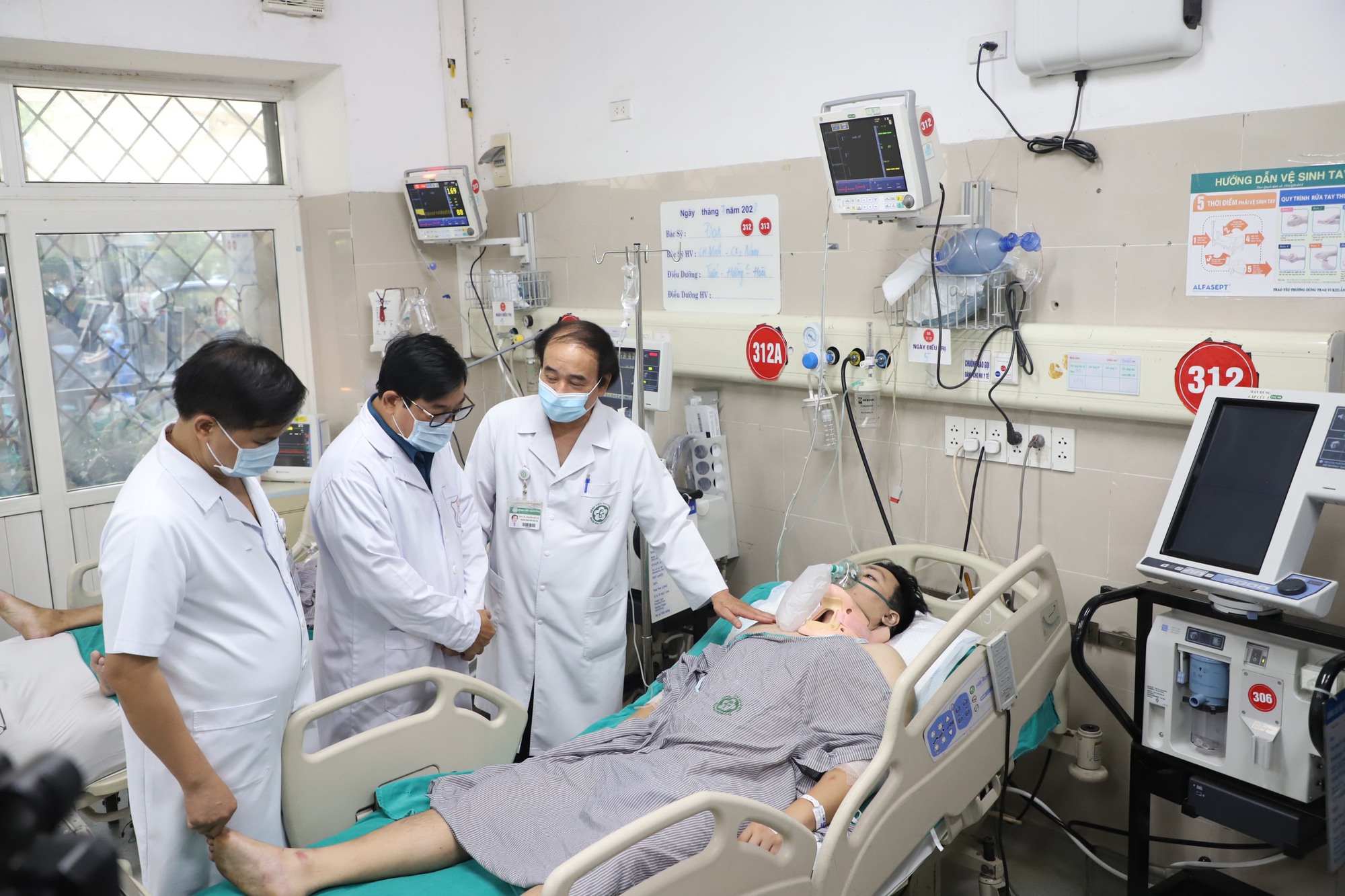 PGS.TS Lương Ngọc Khuê , PGS.TS Đào Xuân Cơ và PGS.TS Nguyễn Văn Chi - Chuyên gia cấp cứu của Bệnh viện Bạch Mai thăm, động viên và hội chẩn tình hình sức khoẻ của nam bệnh nhân vụ cháy chung cư mini đang điều trị tại Bệnh viện Bạch Mai sáng 13-9.