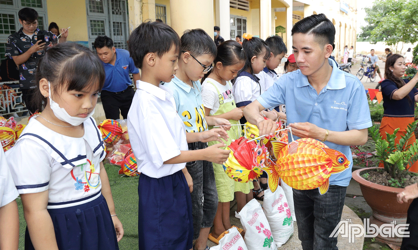 Diễn viên Trung Cang trao quà cho các em.