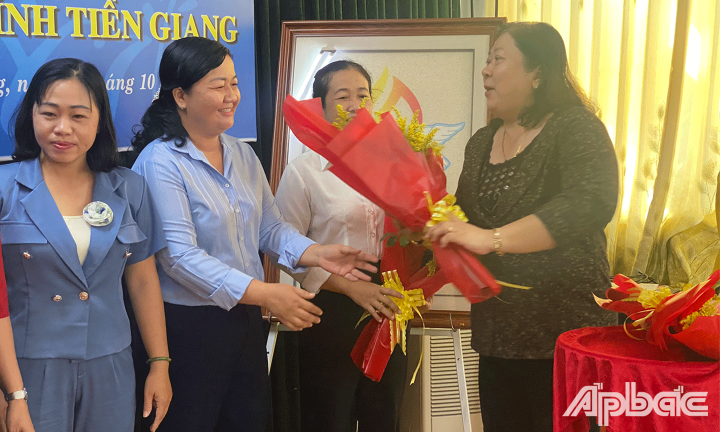 Đại diện Hội LHPN tỉnh Tiền Giang tặng hoa chúc mừng các thành viên trong Câu lạc bộ “Nữ bảo vệ quyền lợi người tiêu dùng” tỉnh Tiền Giang 