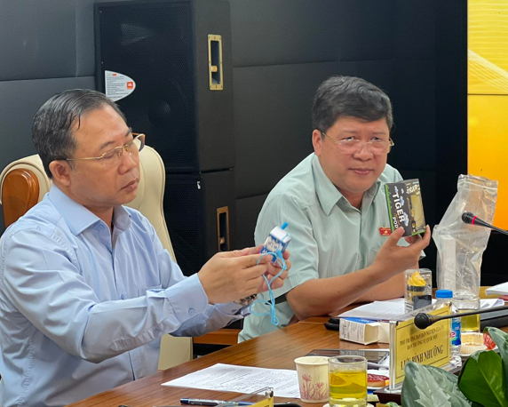 Các đại biểu Quốc hội Tạ Văn Hạ và Lưu Bình Nhưỡng xem xét các sản phẩm thuốc lá mới nhập lậu.
