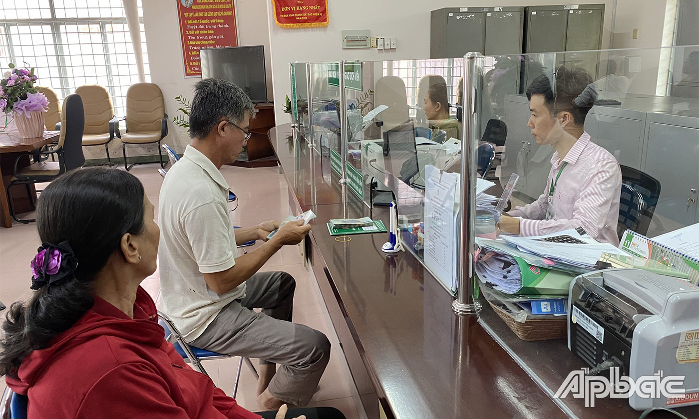 Đại diện gia đình người vay vốn nhận tiền tại Ngân hàng chính sách xã hội huyện