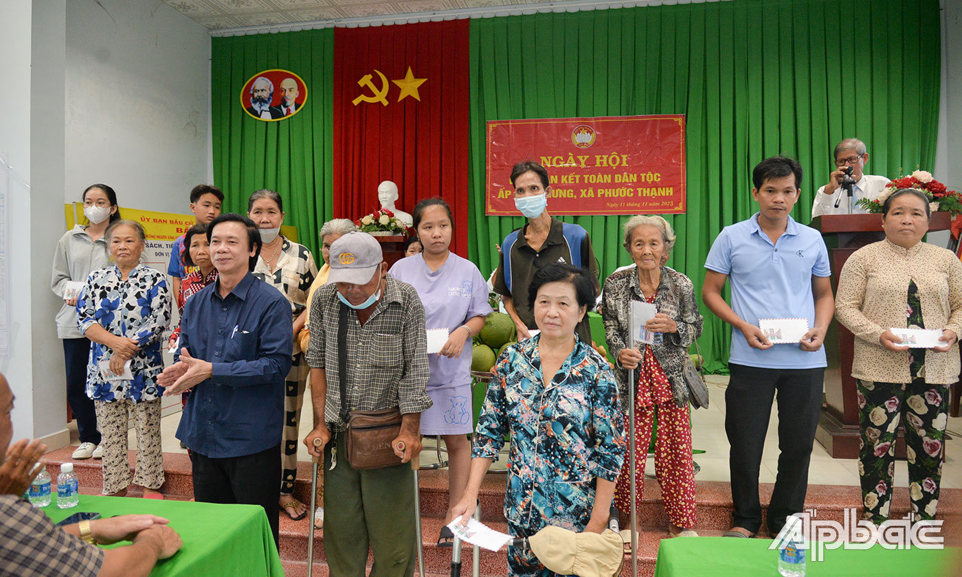 Đồng chí Nguyễn Văn Danh trao 25 phần quà của Ban Vận động Quỹ vì người nghèo tỉnh Tiền Giang cho các hộ nghèo, hộ cận nghèo trên địa bàn ấp Long Hưng.